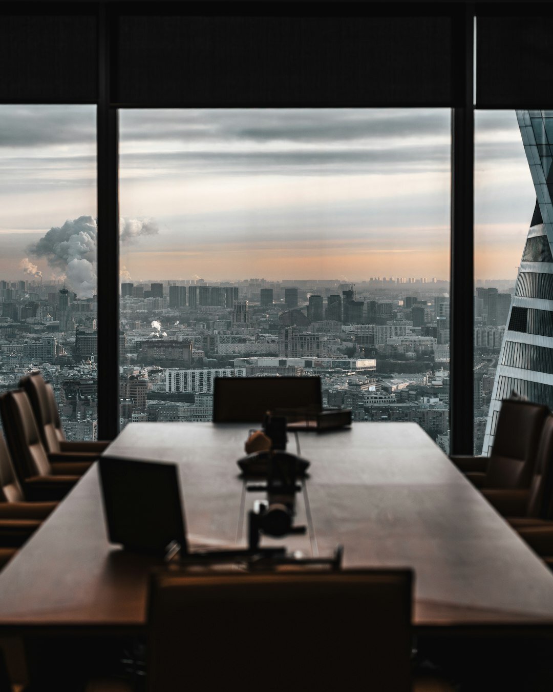 Empty modern boardroom with large windows and city skyline view